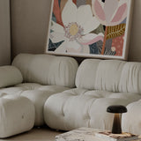 Beige sofa with a marble coffee table and abstract floral artwork in a living room.