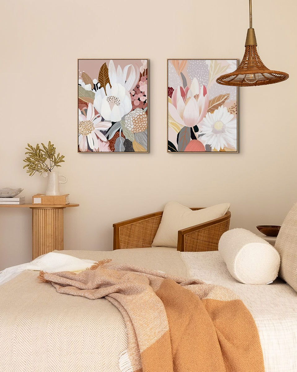 Two framed canvas artworks featuring abstract floral patterns, hung on a wall in a cozy room setting with a bed, chair, and lamp.