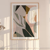 A framed abstract floral print hanging on a wall, with soft lighting and shadows across the image.