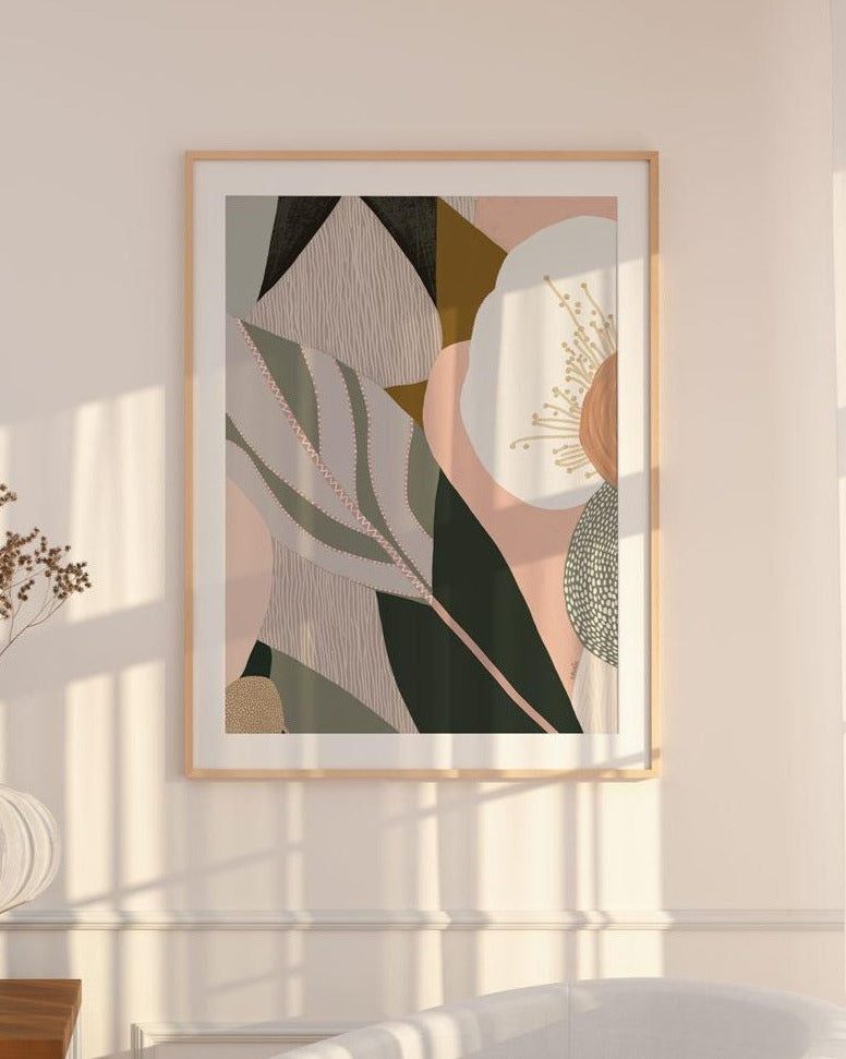 A framed abstract floral print hanging on a wall, with soft lighting and shadows across the image.