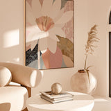 A framed canvas print titled 'Reverie', depicting an abstract floral arrangement in a soft color palette, displayed in a modern interior setting with minimalist furniture and decor.