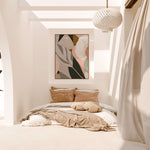 A framed canvas print titled 'Odeletta', featuring abstract geometric patterns in pink and navy colors, displayed above a wooden bench in a minimalist interior setting.