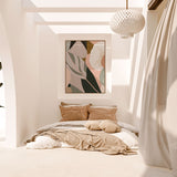 A framed canvas print titled 'Odeletta', featuring abstract geometric patterns in pink and navy colors, displayed above a wooden bench in a minimalist interior setting.