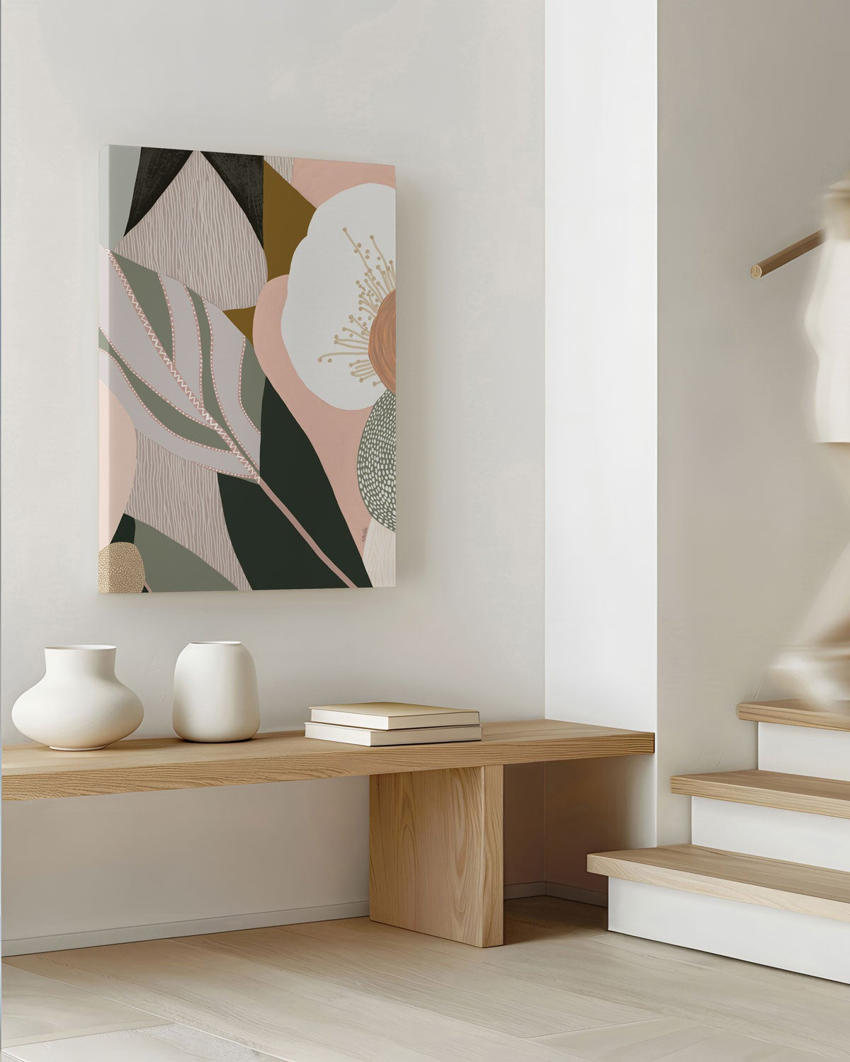 A framed canvas print titled 'Odeletta', featuring abstract geometric patterns in pink and navy colors, displayed above a wooden bench in a minimalist interior setting.