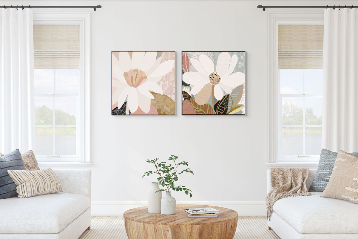 A pair of framed canvas prints titled 'Reverie No.2' and 'Magnolia' displayed in a living room setting with a natural oak frame and a classic black moulding, respectively.
