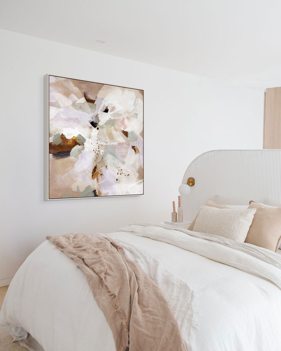 Decorative abstract painting on a wall above a bed with neutral bedding.