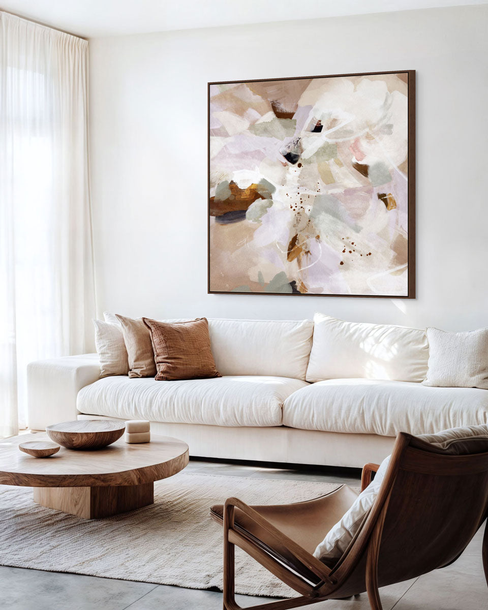 Modern living room with a white sofa, wooden coffee table, and abstract floral artwork.