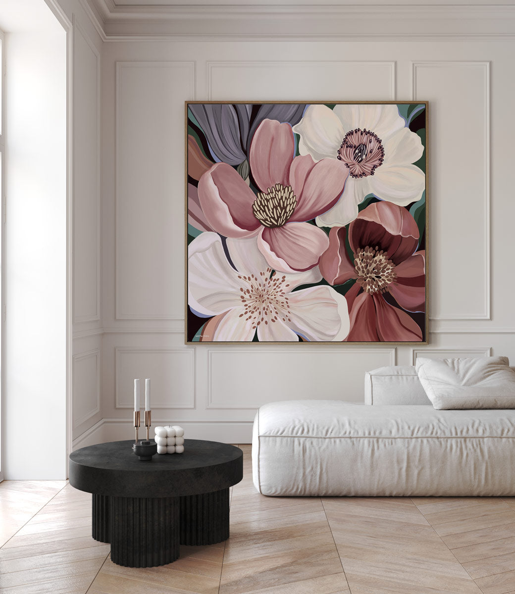 Floral artwork on a wall above a white sofa in a living room.