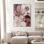 Living room with a floral painting on the wall above a beige sofa.