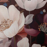 A close-up of a floral painting or print featuring large pale pink blossoms, a dark burgundy flower with yellow stamens, and muted green and blue leaves on a dark brown background.