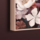 A close-up of a framed floral art print hanging on a dark brown wall. The artwork features large white and pale pink flowers with mauve and brown petals, and the light natural wood frame is visible at the top and left edges.