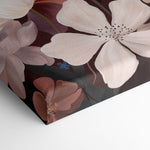 A close-up of a stretched canvas featuring large cream and dusty pink flowers with brown and muted purple accents on a dark background, shown folded over on a white surface.