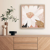 Framed floral artwork on a wall above a wooden cabinet with decorative items.