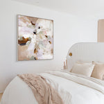 Decorative abstract painting on a wall above a bed with neutral bedding.