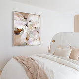 Decorative abstract painting on a wall above a bed with neutral bedding.