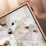 Framed abstract artwork with a hand holding it